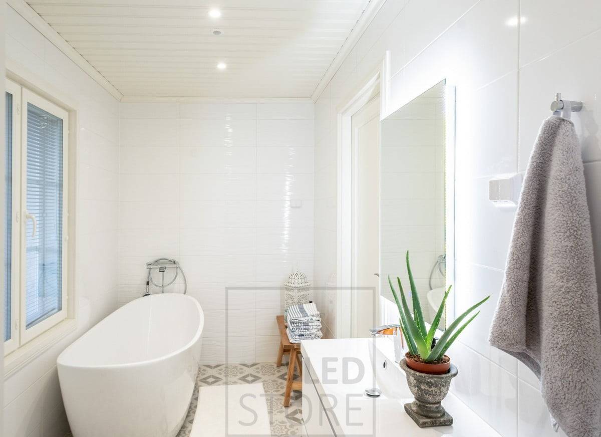 Ceiling-mounted spotlights provide the general lighting in the bathroom, supported by a lighted mirror.