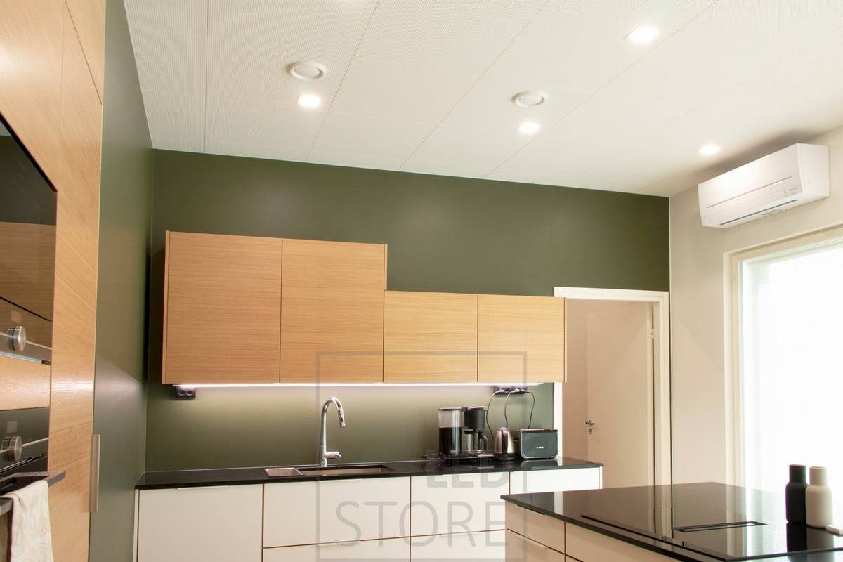 Flat ceiling lighting in the kitchen with square LED panels and a LED strip light at the bottom of the upper cabinets as flat lighting. Ledstore.fi