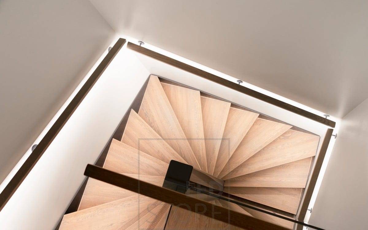 The staircase handrail has an LED strip pointing downwards, illuminating the steps. Ledstore.fi