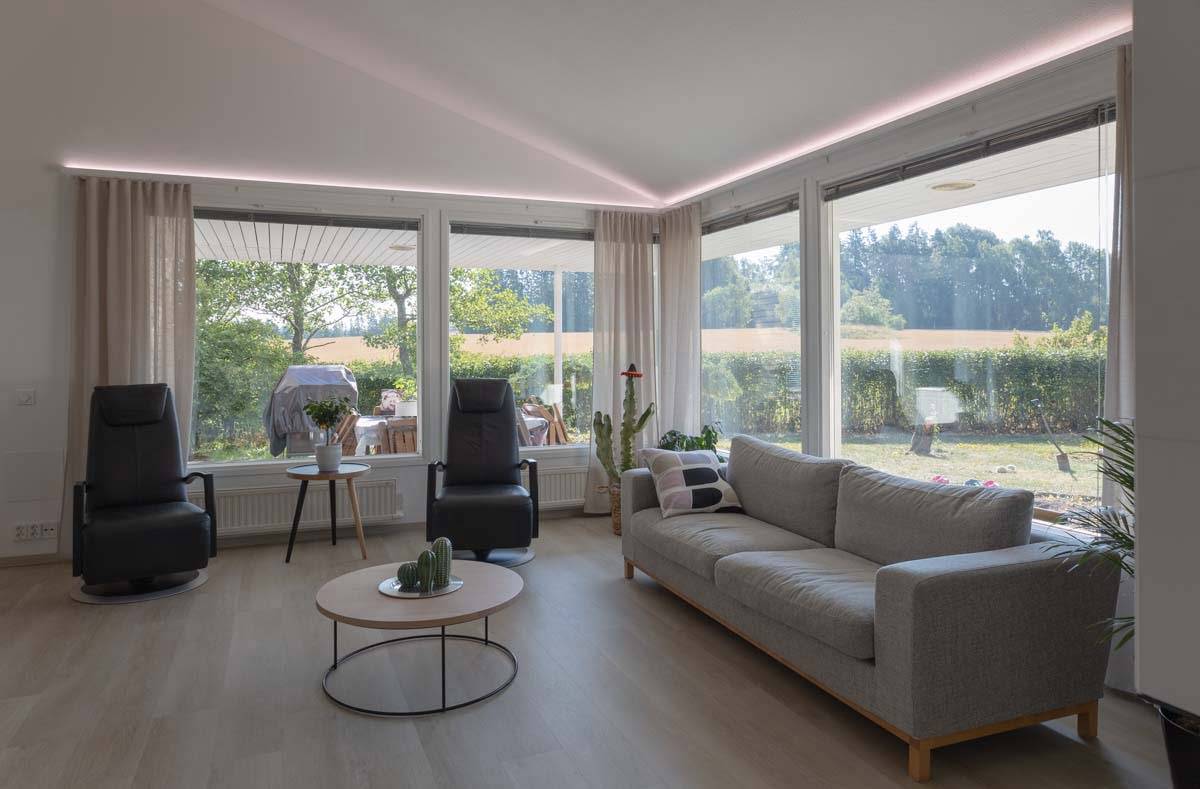 Led strip lighting towards the ceiling above the windows. Aluminium profile for indirect lighting and a neutral white shade on the strip. ledstore.fi