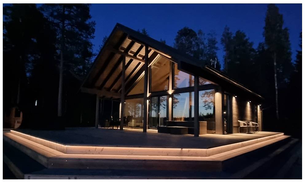 An illuminated LED strip runs along the edge of a large terrace at dusk.