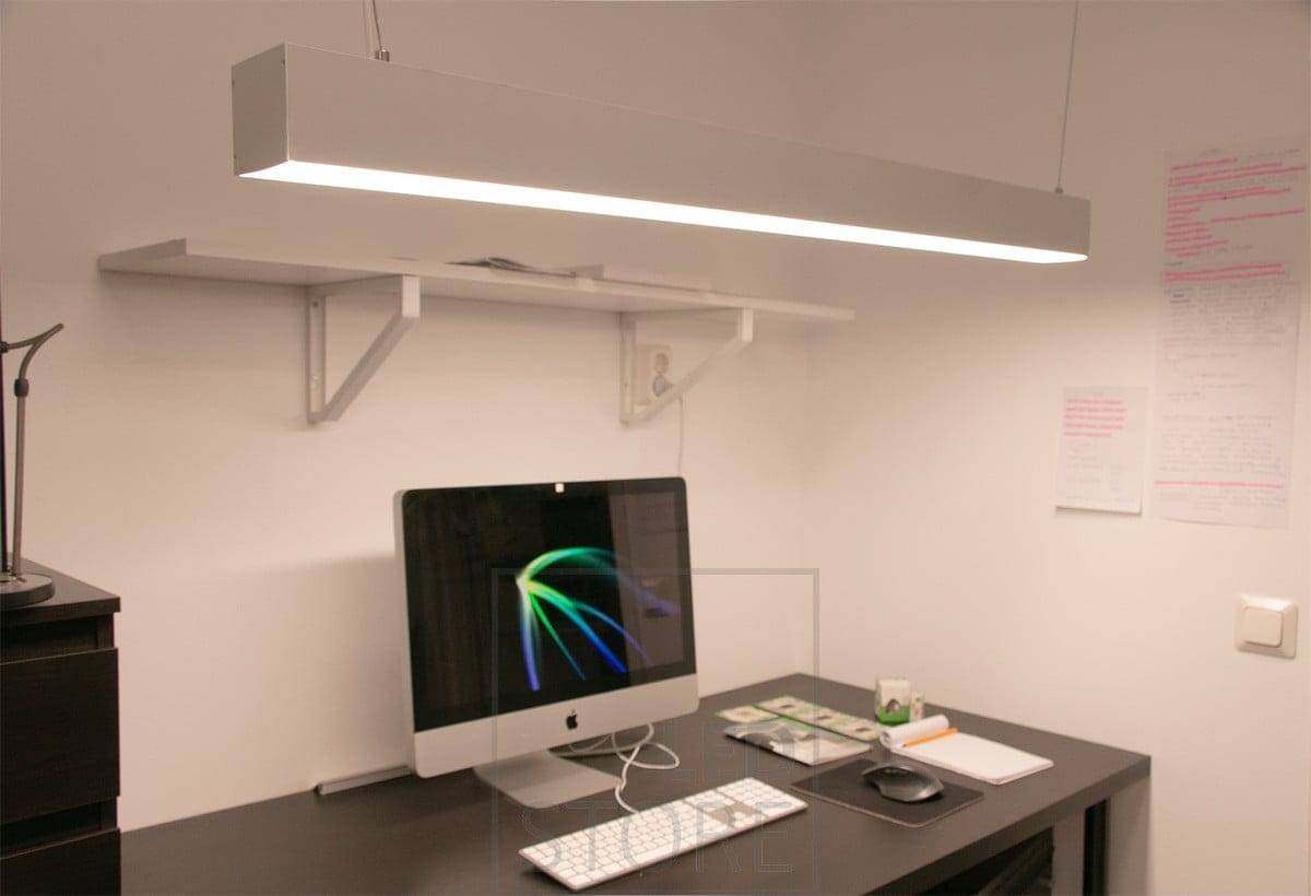 A workstation with a pendant light above it.