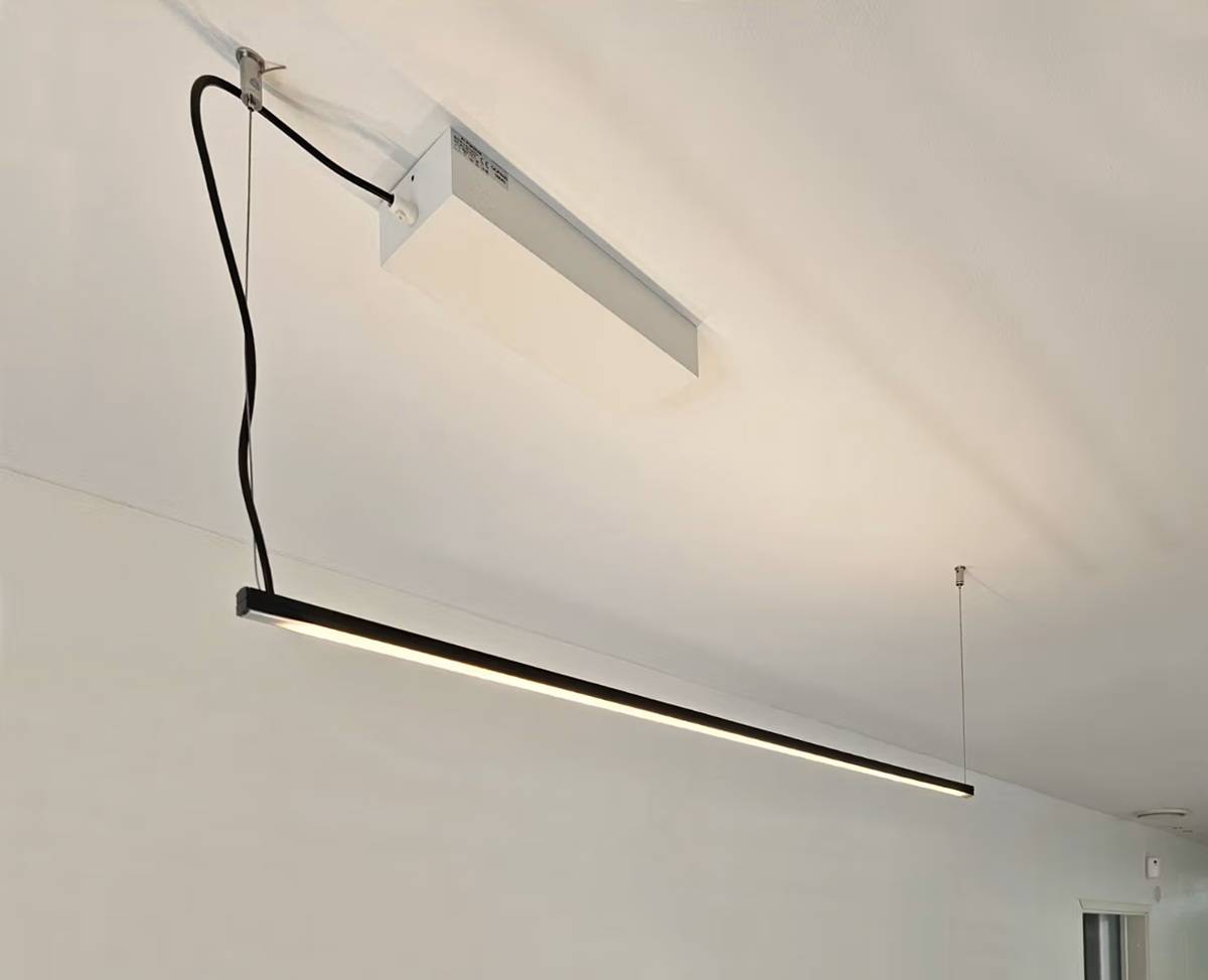 The modern Luks linear luminaire hangs from the white ceiling and meets the requirements of the EN 12464-1 standard at LedStore.fi.