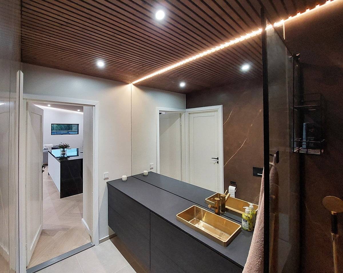 The bathroom has adequate lighting with a combination of 9W spotlights and LED strip lighting