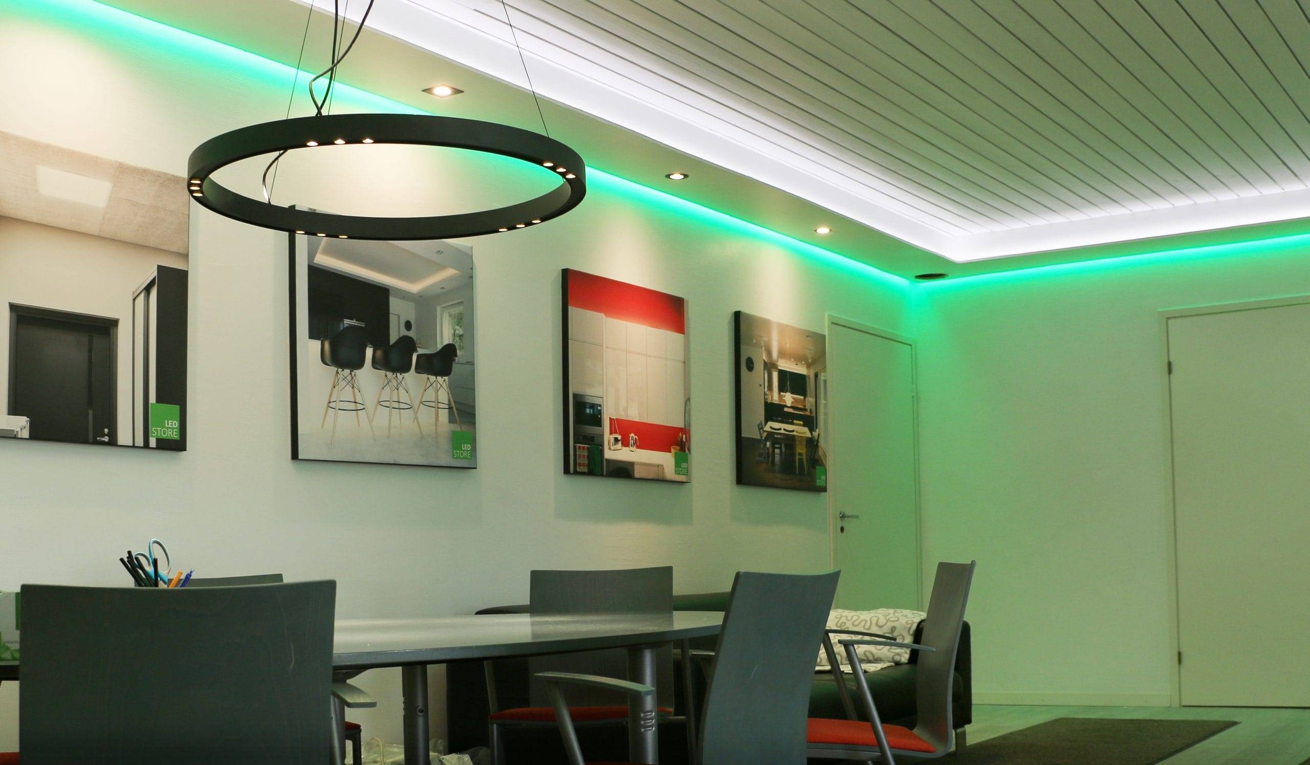 Modern office with LED chandelier, gray chairs, kitchen-themed decor, and ceiling edge LED strip lighting for a bright, contemporary ambiance.