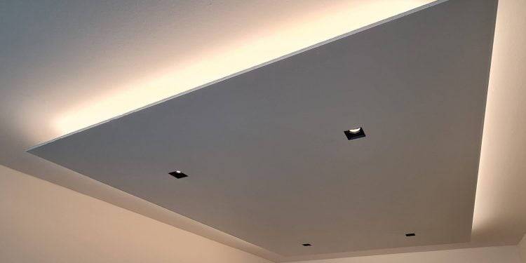 A modern ceiling solution with a recessed rectangular panel with four square LED lights. The edges of the panel glow softly, creating subtle lighting on the ceiling and walls for a contemporary look. This style can be found in LedStore.fi's wide range of LED lighting.
