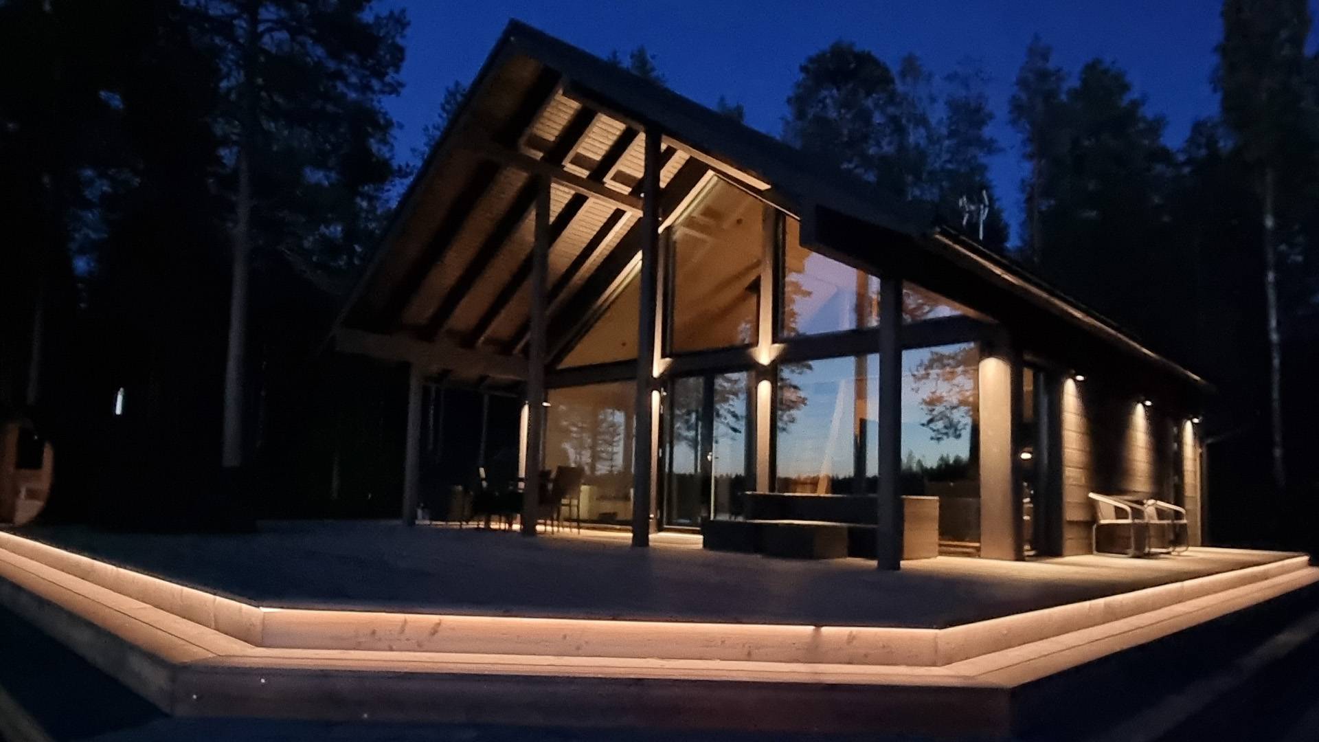 Summer cottage lit with wall lights and the terrace elevation with led strip. 
