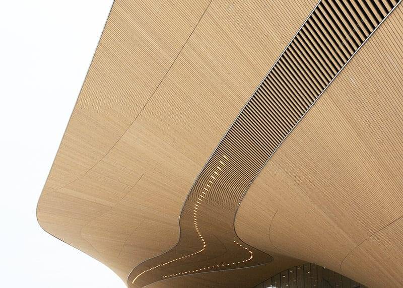 A curved wood texture with a wavy design and recessed LED lights that accentuate the modern abstract look against a white background.