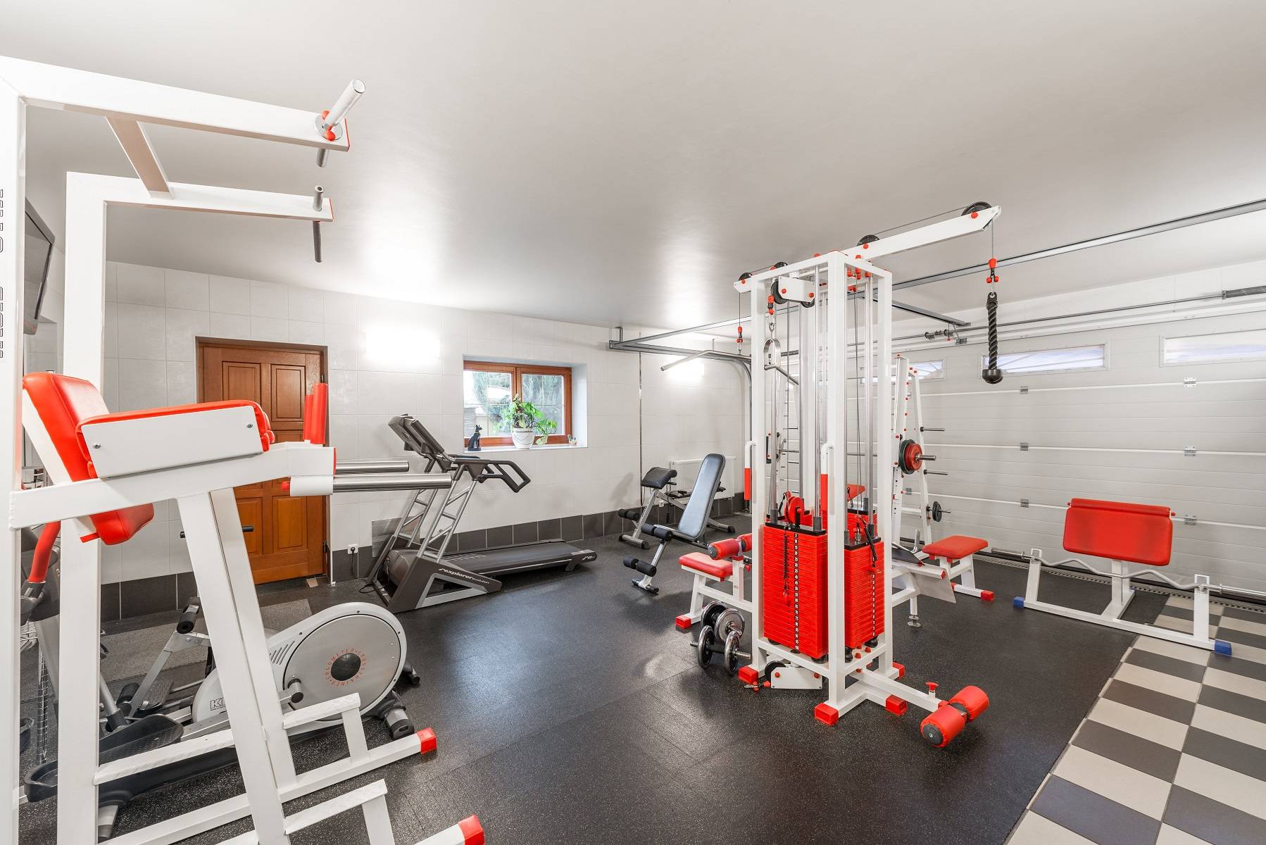 Garage lit with bright wall lights when the space is used as a gym.