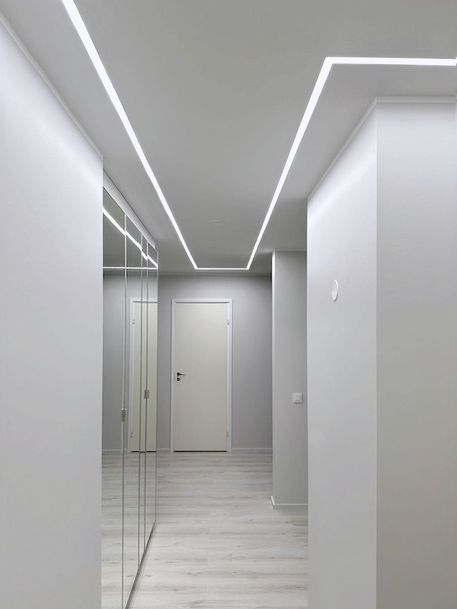 Recessed LED strip lighting in the hallway continues seamlessly into the corridor.